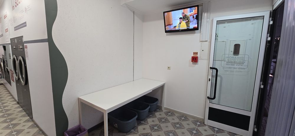 Zona de espera com televisão da Lavandaria Alvelos